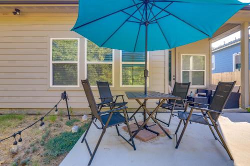 a table and chairs with an umbrella on a patio at Newly Constructed Mansfield Home with Fenced Yard! in Mansfield