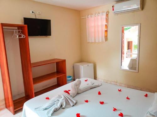a bedroom with a bed with roses on it at Pousada Hippocampus in Porto De Galinhas
