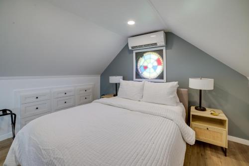 ein Schlafzimmer mit einem weißen Bett und einem Fenster in der Unterkunft Wolf Lake Vacation Rental with Fire Pit! in Jackson