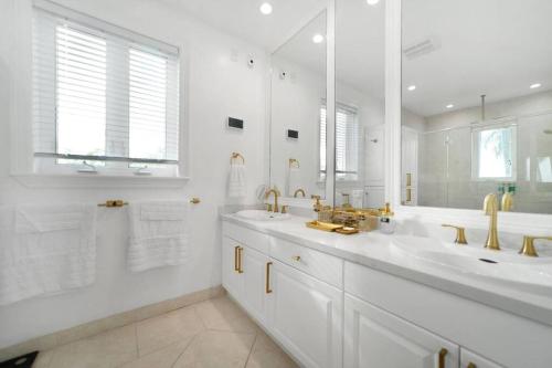 a white bathroom with two sinks and a large mirror at Paradise Retreat, A Tropical Oceanfront Villa in Freeport
