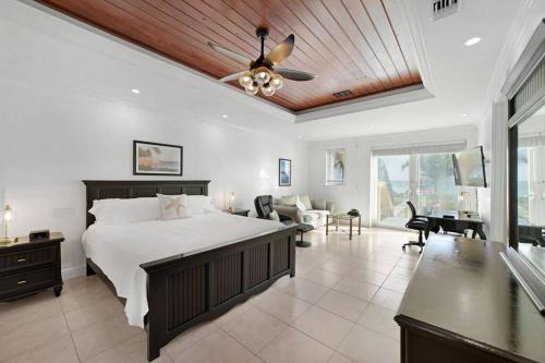 una camera con letto e ventilatore a soffitto di Paradise Retreat, A Tropical Oceanfront Villa a Freeport