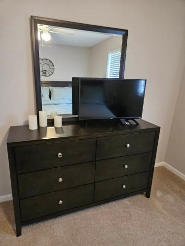 a dresser with a flat screen tv and a mirror at GSRealty in Americus