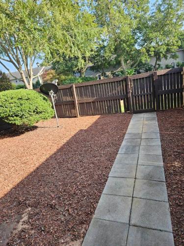 a garden with a wooden fence and a walkway at GSRealty in Americus
