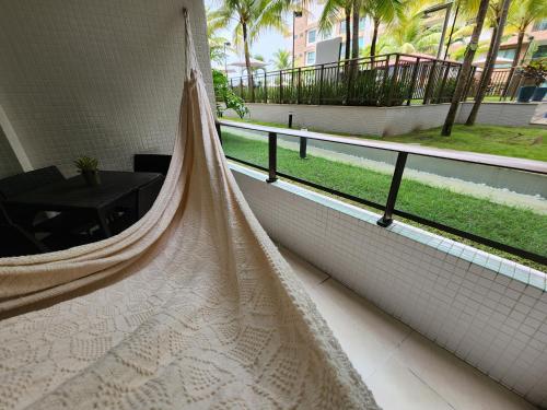 a hammock on a balcony with a view of a courtyard at Luxor Paulo Miranda Home Service in João Pessoa