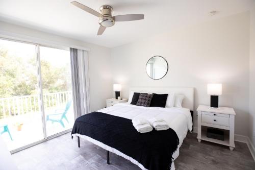 Dormitorio blanco con cama y ventana grande en Peaceful Home in Serenity Disney area, en Orlando
