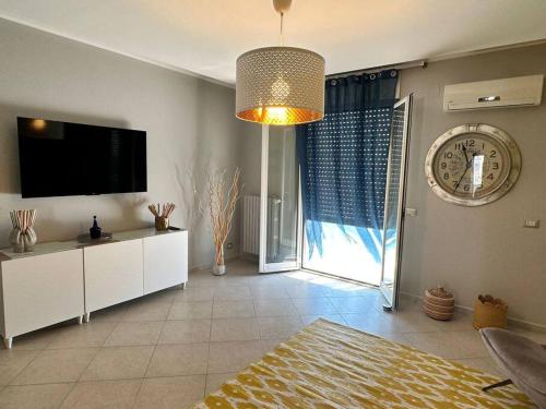 ein Wohnzimmer mit einem TV und einem großen Fenster in der Unterkunft Faro Sul Mare Luxury Apartment - Zona Fiera in Bari