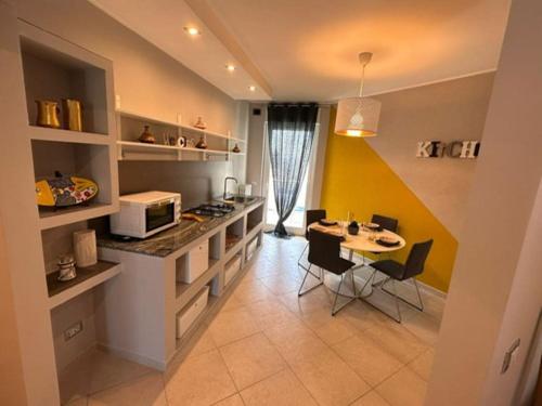 a kitchen with a counter and a table with chairs at Faro Sul Mare Luxury Apartment - Zona Fiera in Bari