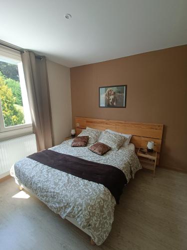 a bedroom with a large bed and a window at CONTACT HOTEL LE BOIS SAUVAGE in Saint-Agrève