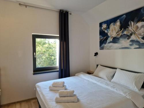 um quarto com uma cama com duas toalhas em Casa 7 SATE apartament em Săcele