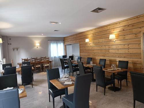 a restaurant with wooden walls and tables and chairs at CONTACT HOTEL LE BOIS SAUVAGE in Saint-Agrève
