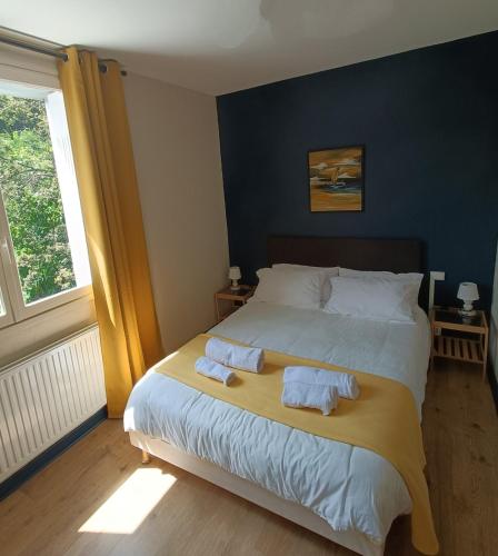 a bedroom with a bed with two towels on it at CONTACT HOTEL LE BOIS SAUVAGE in Saint-Agrève