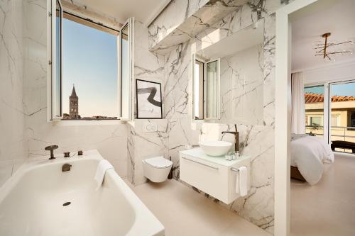 Un baño blanco con lavabo e inodoro. en The Central Pearl Apartment Zadar, en Zadar