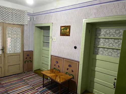 um quarto com duas portas e uma mesa em CASA LUCIAN em Cîrţişoara