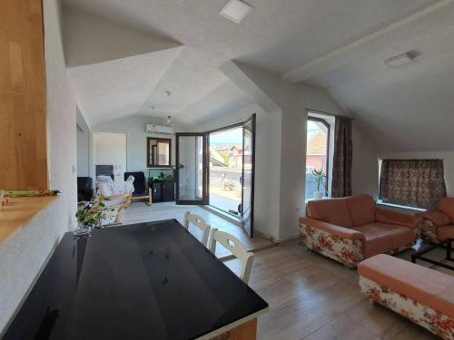 a living room with a couch and a table in it at Apartman Gradina in Doboj