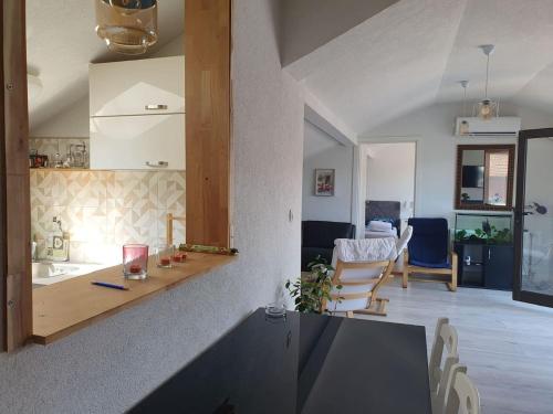 een keuken en een woonkamer met een tafel en stoelen bij Apartman Gradina in Doboj