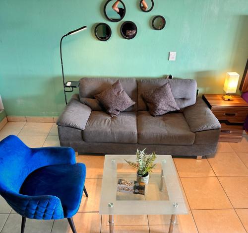 a living room with a couch and a blue chair at Brisa del Mar #6 in Brisas de Zicatela