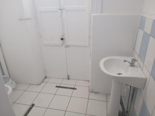a white bathroom with a sink and a shower at Hostal 4 Estaciones in Los Andes