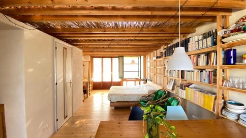 Pokój z drewnianymi sufitami, łóżkiem i półkami na książki w obiekcie San Liberale sul mare w Trapani