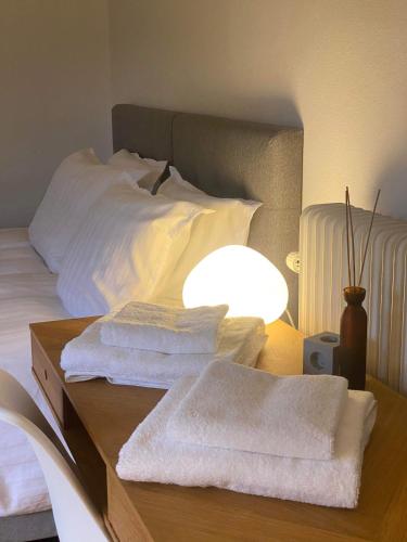 a bed with a table with towels on it at Unik BnB midt i byen in Herning