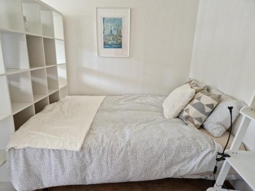 a small bedroom with a bed with white sheets at Nära centrum in Gothenburg