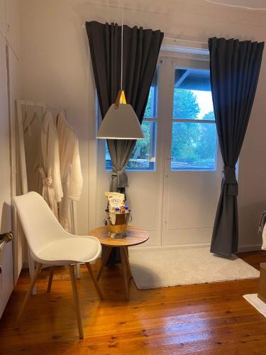 a dining room with a table and a chair and a window at Unik BnB midt i byen in Herning