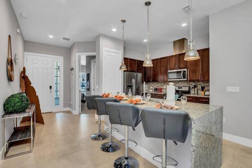 a kitchen with a bar with chairs and a table at NEW awesome dream house, 5 Min to Disney in Orlando