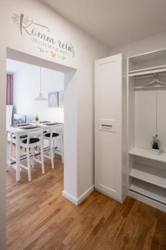 a white room with a table and a dining room at Goethe Palais Suite Charlotte 4P l Lift I ParkplatzI Zentrum I Helios in Aue