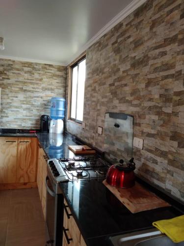 a kitchen with a stove with a tea kettle on it at S&J Casa Cabaña in El Tabo