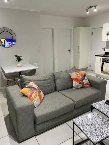 a living room with a couch and a table at Dmn City Apartment at Junction in Windhoek