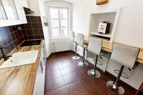 une cuisine avec un évier et un comptoir avec des chaises dans l'établissement At the Blue Lion & Parking Assistance, à Prague