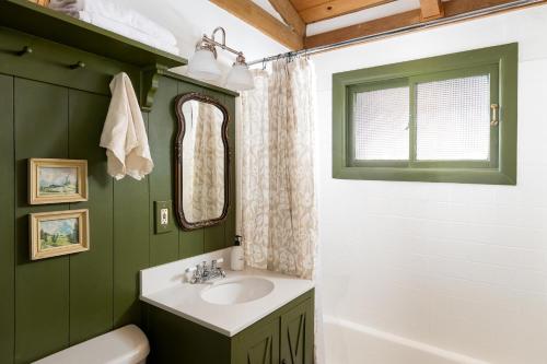 baño con paredes verdes, lavabo y bañera en 056 - Beaumont Hideaway, en Big Bear City