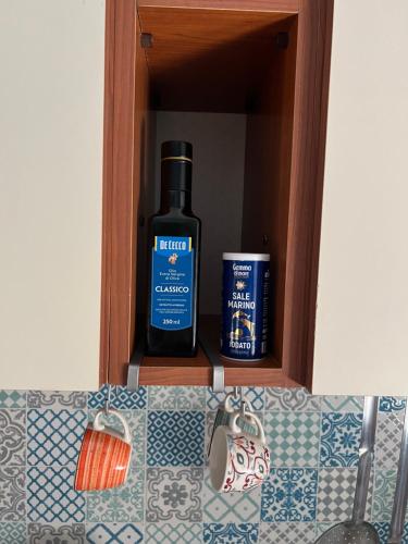 a bottle of alcohol sitting in a kitchen cabinet at Casa al mare in Scauri