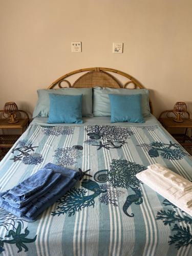 - un lit avec une couverture bleue et blanche dans l'établissement Casa al mare, à Scauri