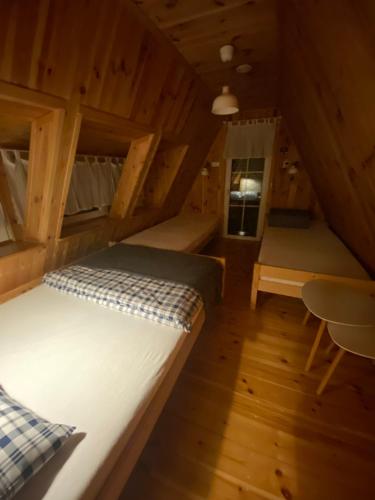 Zimmer mit einem Bett und einem Stuhl in einer Hütte in der Unterkunft Kamień na Kaszubach in Kamień
