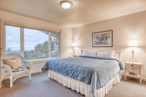 a bedroom with a bed and a window and a chair at Sandpiper Retreat in Waldport