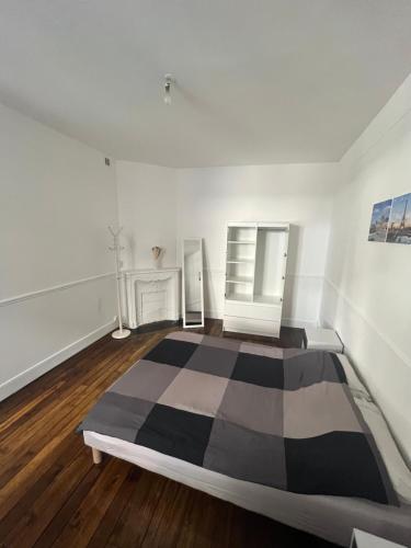 ein Schlafzimmer mit einem schwarz-weißen Bett in einem Zimmer in der Unterkunft Charmant studio in Clichy