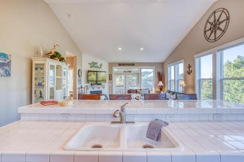 a kitchen with a sink and a living room at The Mermaid in Lincoln City