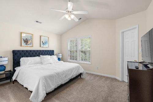 a bedroom with a bed and a ceiling fan at Exquisite E Charlotte house in Charlotte