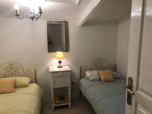 a bedroom with two beds and a tv on the wall at Gîte des Tournesols in Oradour-Fanais