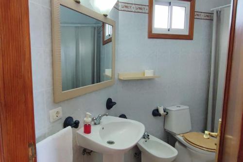 uma casa de banho com um lavatório, um WC e um espelho. em Finca de Sal em Mazo