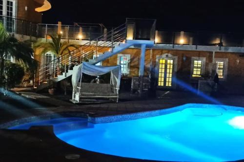 a swimming pool in front of a building at night at Finca de Sal in Mazo