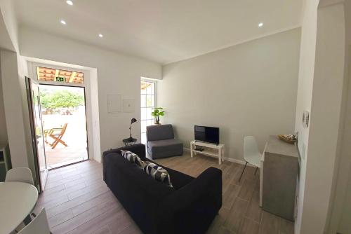 a living room with a couch and a table at Casa do Chafariz - Guest House in Cercal