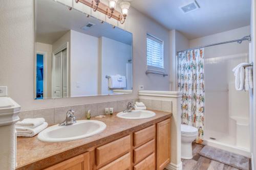 a bathroom with two sinks and a toilet and a mirror at The Osprey - Meredith Lodging in Bend