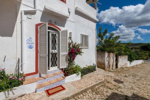 a white house with a red door and stairs at Casa Cecilia Apartment Algarve in Alte