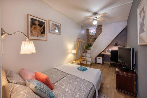 a bedroom with a bed and a tv and a staircase at Casa Cecilia Apartment Algarve in Alte