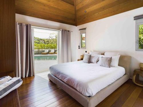 a bedroom with a large bed and a large window at Villa Vi - St Barth in Saint Barthelemy