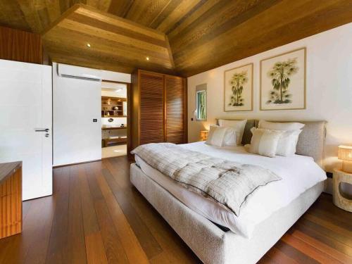 a bedroom with a large bed and a wooden ceiling at Villa Vi - St Barth in Saint Barthelemy
