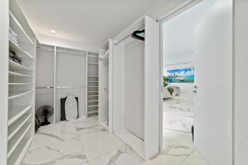 a walk in closet with white walls and marble floors at Miami House with Hot Pool-spa & Pool table L48 in Hialeah
