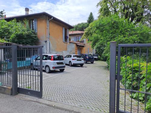 a gate with cars parked in front of a house at Gabbinoholidayhome Appartamento in suggestiva corte in Como