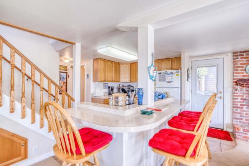 a kitchen with a counter with red cushioned chairs at Siren Song in Lincoln City